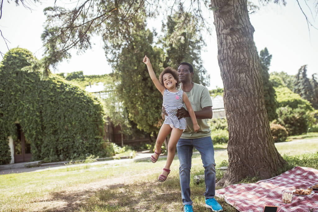 アフリカ系アメリカ人の男と彼の娘は公園で一緒に楽しい時間を過ごした - 写真・画像