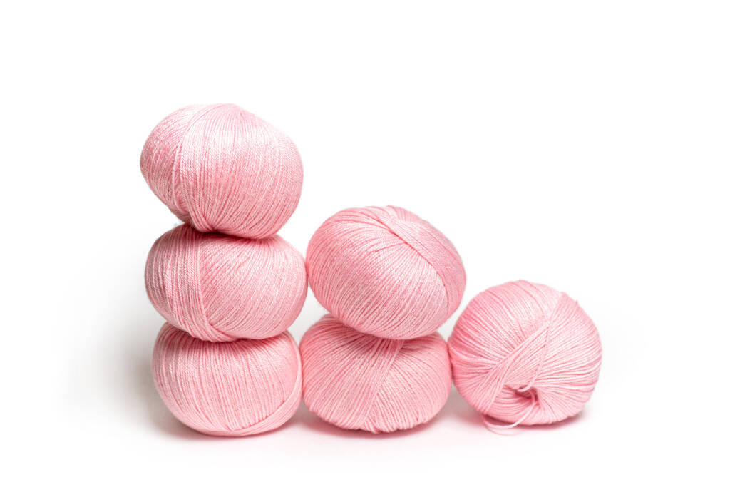 Escarpins roses de fils de laine sur un fond isolé blanc. Balles de laine pour le tricot - Photo, image