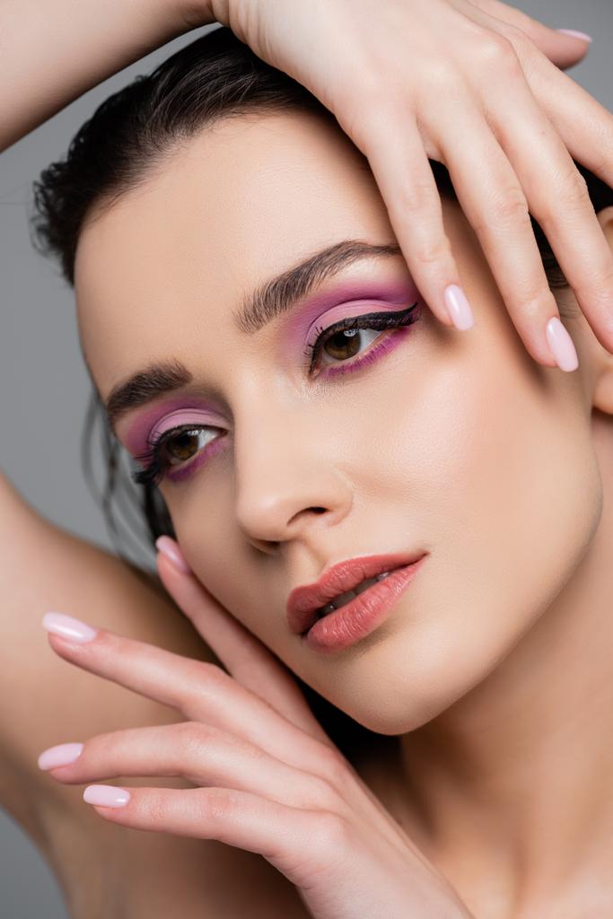 close up of brunette woman with pink eye shadows posing isolated on grey - Photo, Image