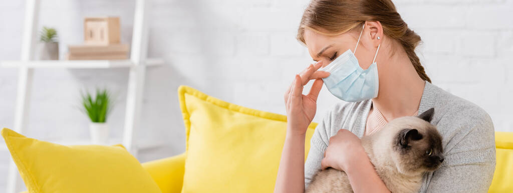 femme au masque médian souffrant de réaction allergique et tenant un chat siamois, bannière  - Photo, image
