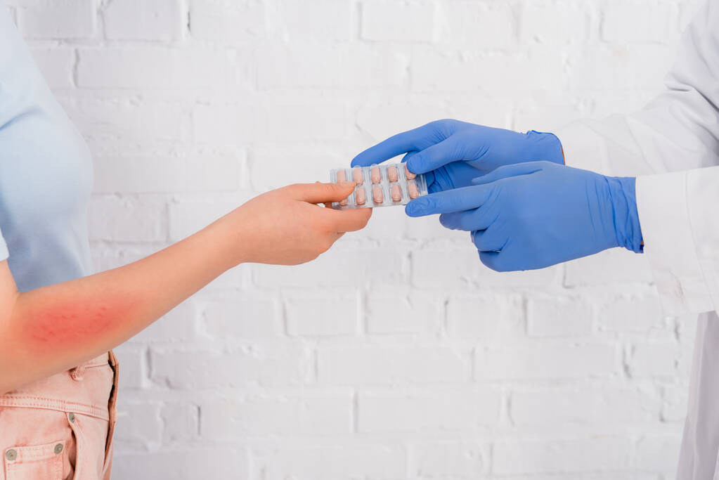 Oříznutý pohled na lékaře dávat pilulky na ženu s alergií  - Fotografie, Obrázek