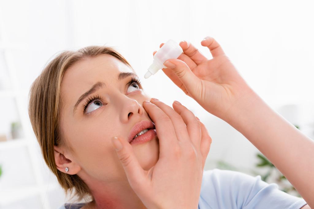 Молода жінка застосовує краплі очей під час алергії
  - Фото, зображення
