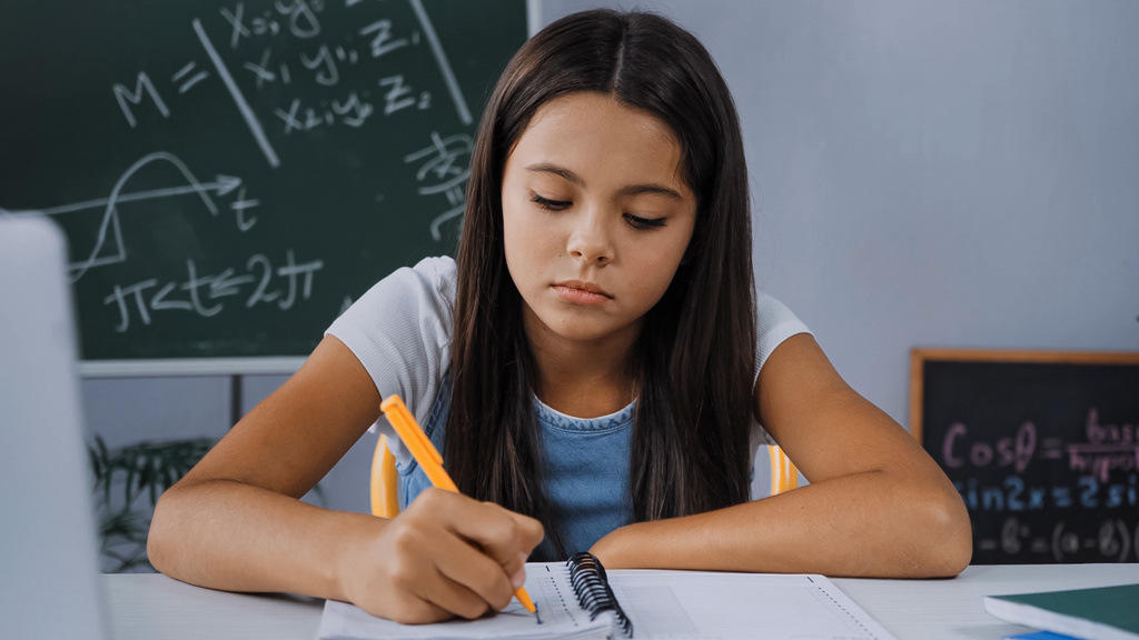 засмучена дитина пише на ноутбуці під час виконання домашнього завдання
  - Фото, зображення