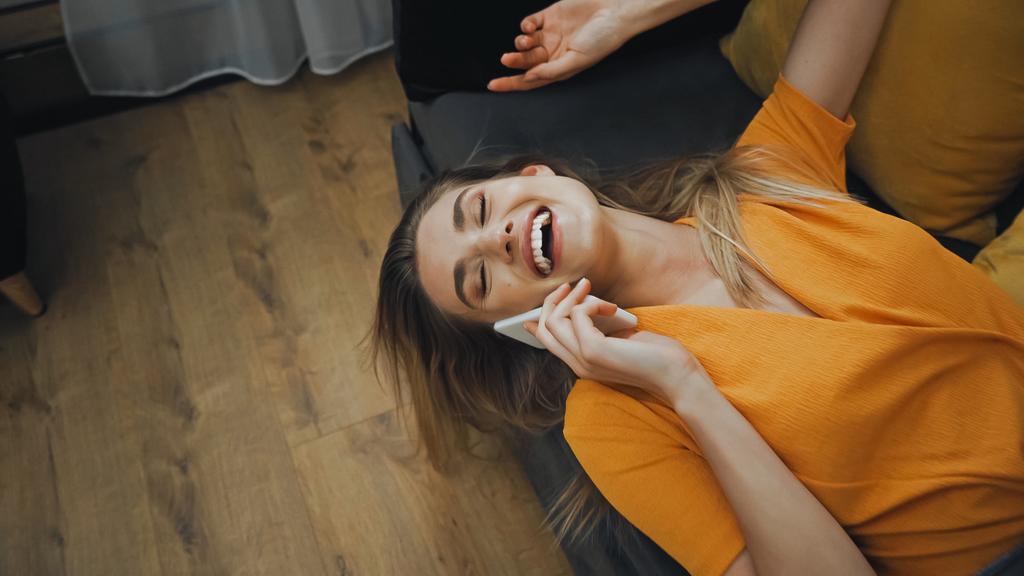 щаслива молода жінка сміється і розмовляє на смартфоні в готельному номері
  - Фото, зображення