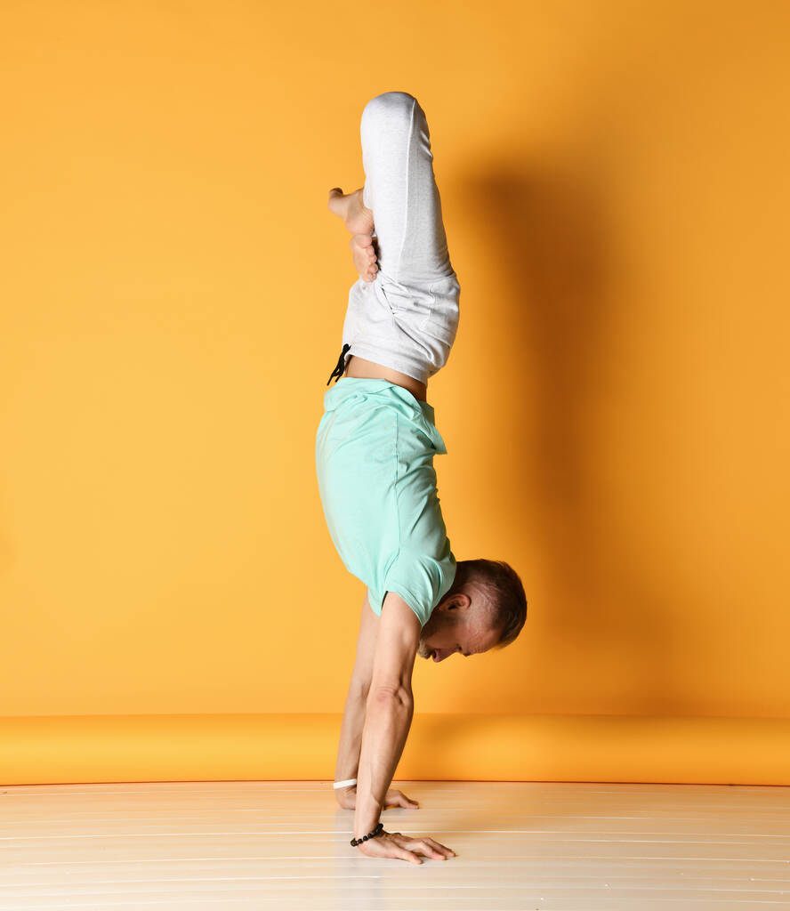Uomo maturo in piedi in posa yoga sul braccio dritto - Foto, immagini
