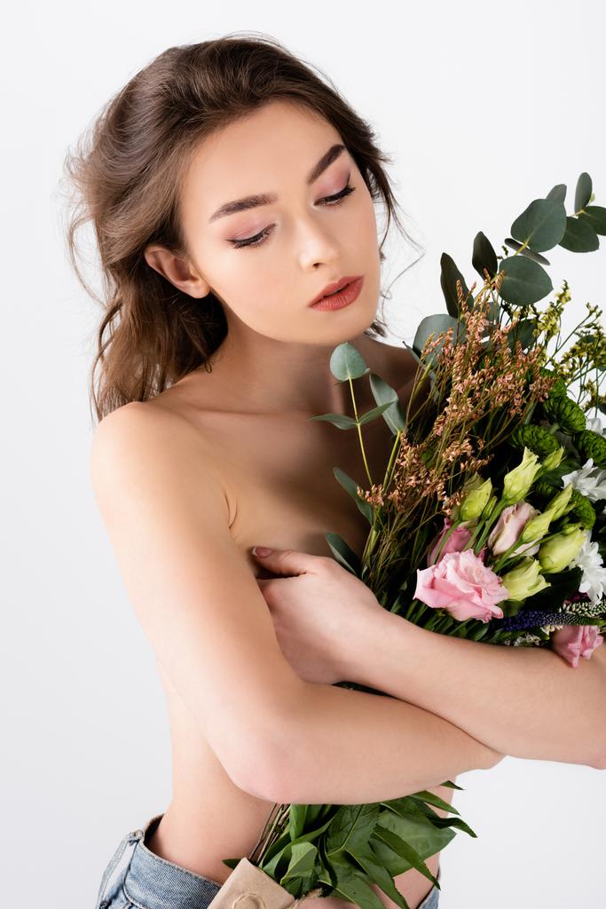 Giovane donna senza camicia che abbraccia fiori isolati su grigio  - Foto, immagini