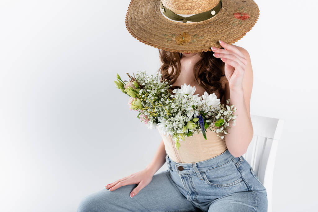 女性で花でブラウスカバー顔とともに太陽帽子孤立オングレー  - 写真・画像