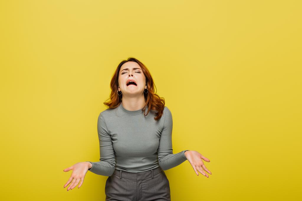 Frustrierte Frau jammert und gestikuliert isoliert auf gelb - Foto, Bild
