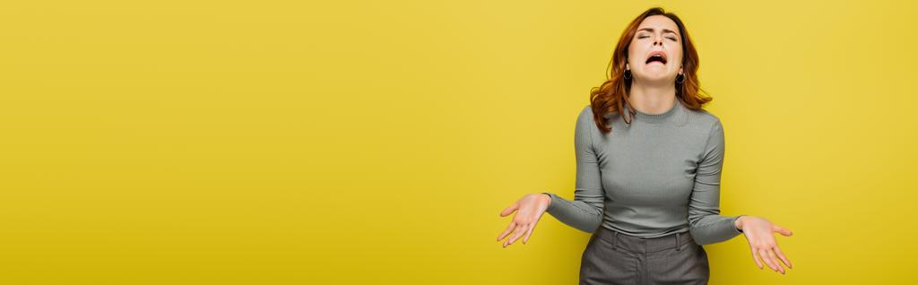 frusztrált nő nyafog és gesztikulál elszigetelt sárga, banner - Fotó, kép