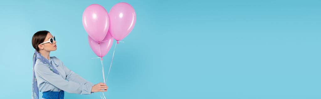 glamour kobieta w okularach stojących z różowymi balonami na niebieskim tle, sztandar - Zdjęcie, obraz