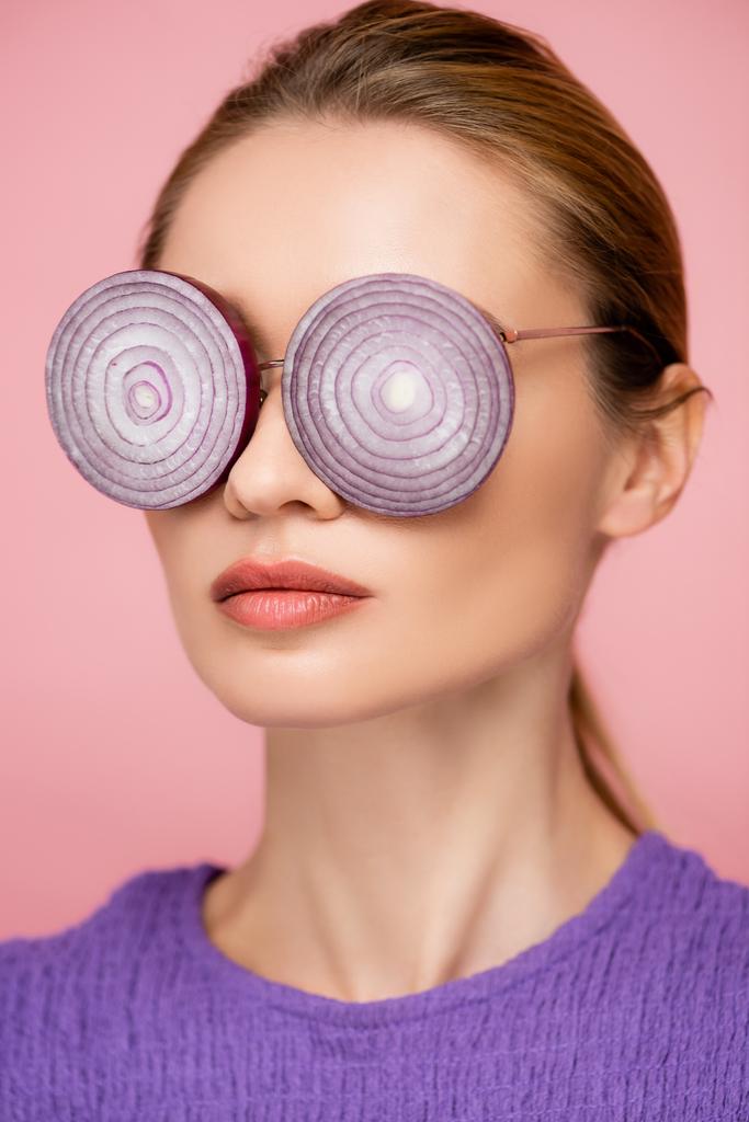 close up view of woman with onion rings eyeglasses isolated on pink, surrealism concept - Photo, Image
