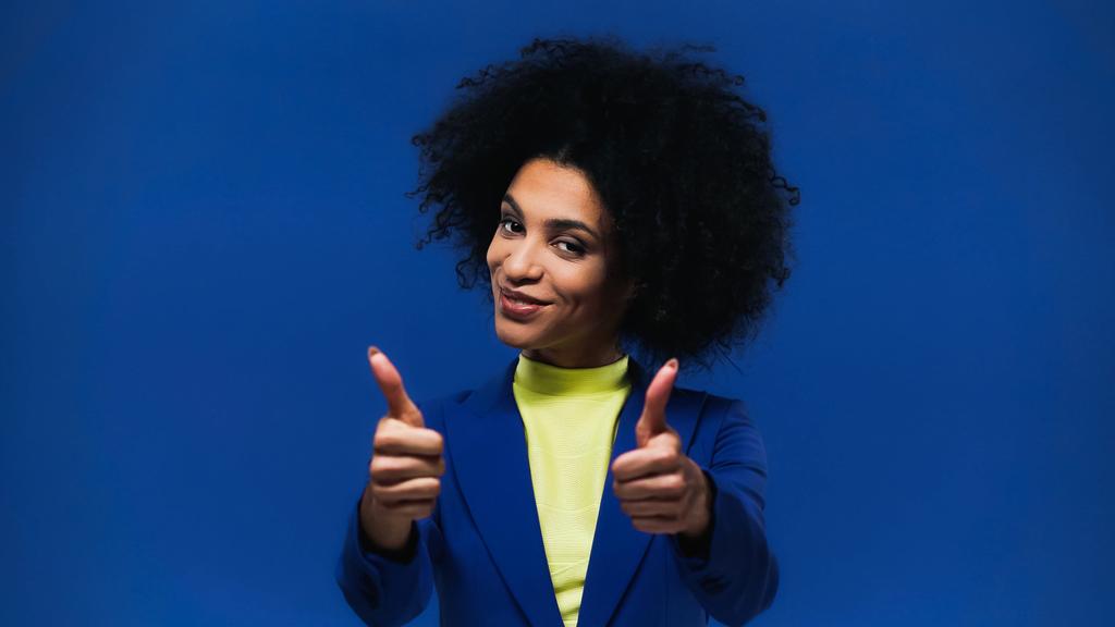 Smiling african american woman showing thumbs up isolated on blue  - Photo, Image