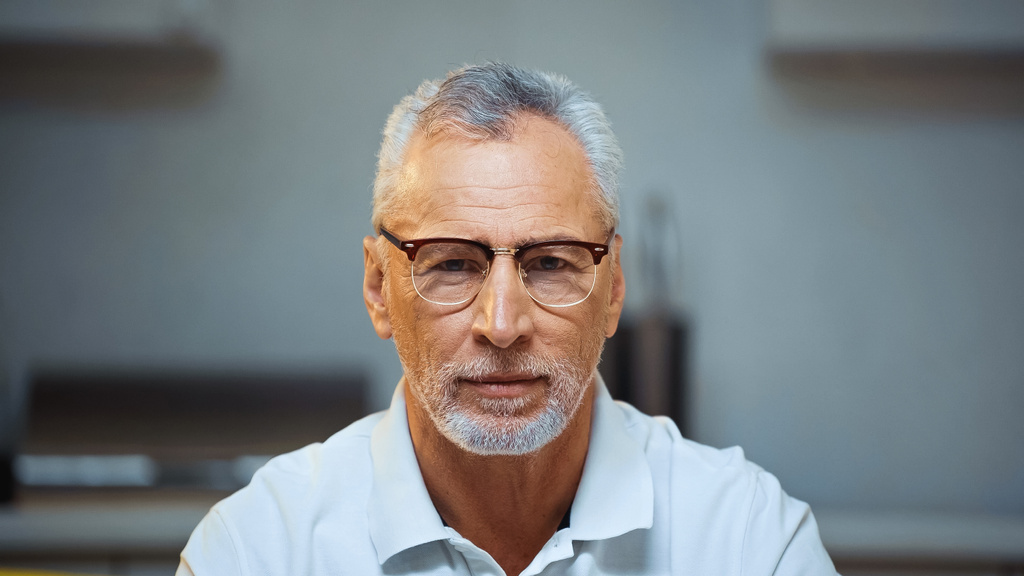 homme âgé positif dans les lunettes regardant la caméra à la maison - Photo, image