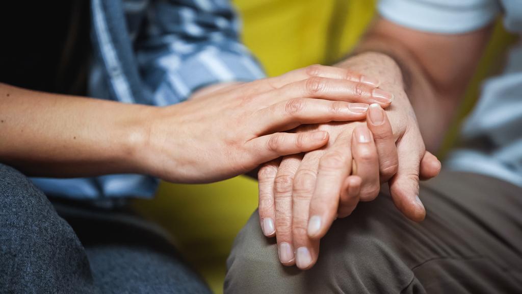 cropped view of woman touching hand on senior husband, blurred background - Photo, Image