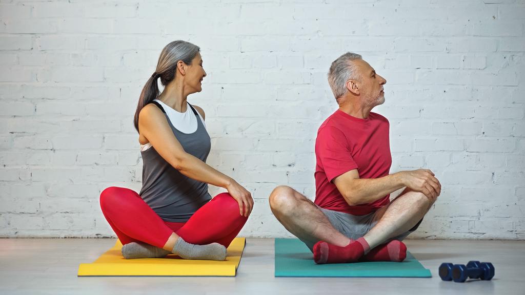 Sportliches Senioren-Paar meditiert in Lotus-Pose auf Fitnessmatten - Foto, Bild
