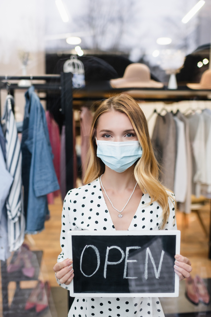 Pozytywne businesswoman w masce medycznej, tablicy z otwartą literą w butiku mody - Zdjęcie, obraz