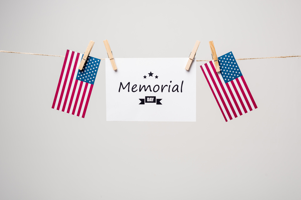 Carte avec lettrage commémoratif et drapeaux américains sur corde isolée sur gris  - Photo, image