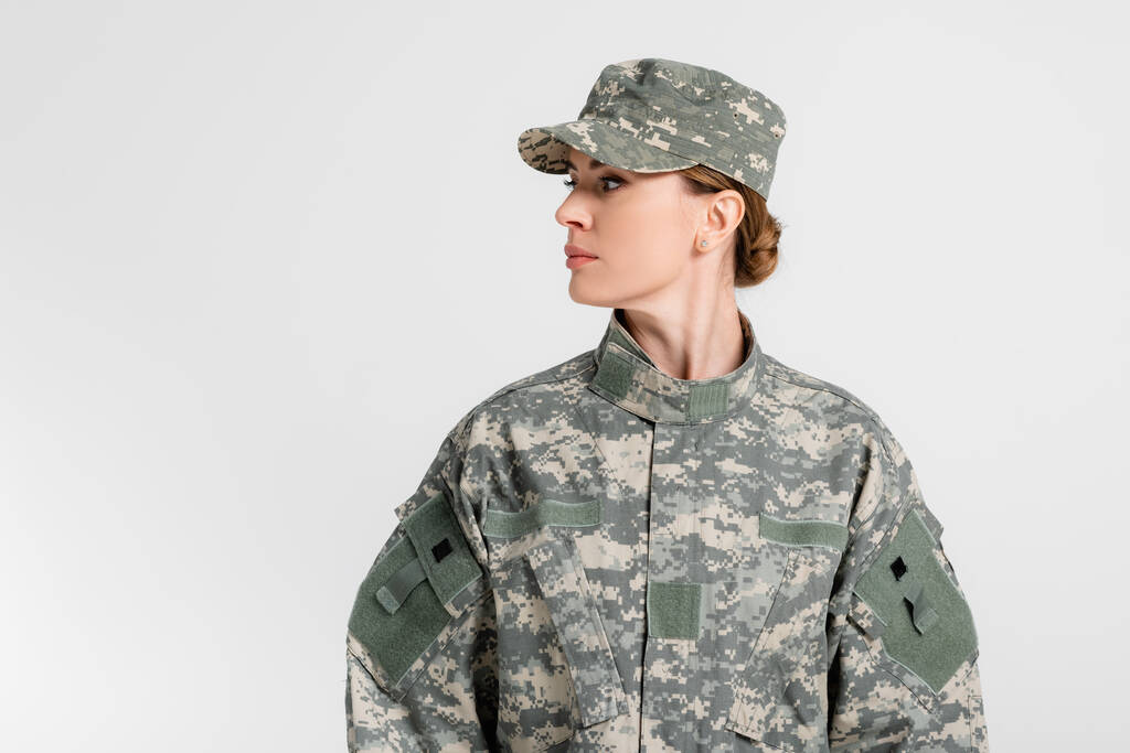 Στρατιώτης με στολή κοιτάζει μακριά απομονωμένος στο γκρι  - Φωτογραφία, εικόνα