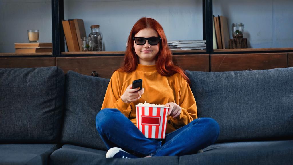 Hymyilevä tyttö 3D-lasit tilalla popcorn ja kaukosäädin kotona  - Valokuva, kuva