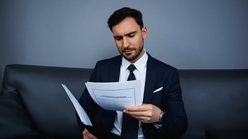 Бизнесмен в формальной одежде держит бумаги в отеле  - Фото, изображение