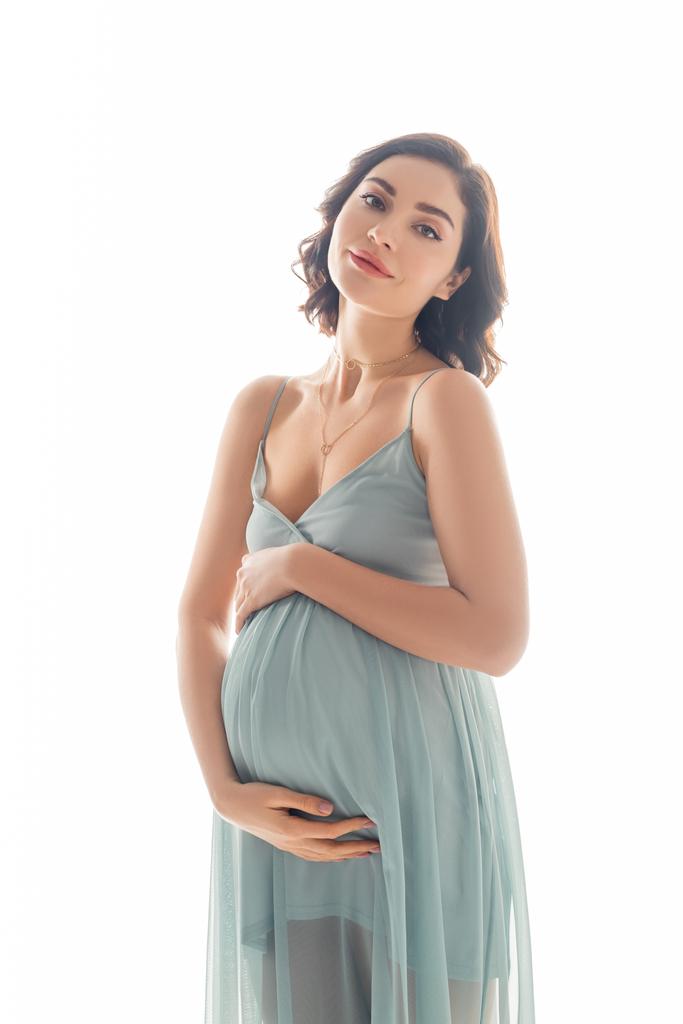 Zwangere vrouw op zoek naar camera geïsoleerd op wit - Foto, afbeelding