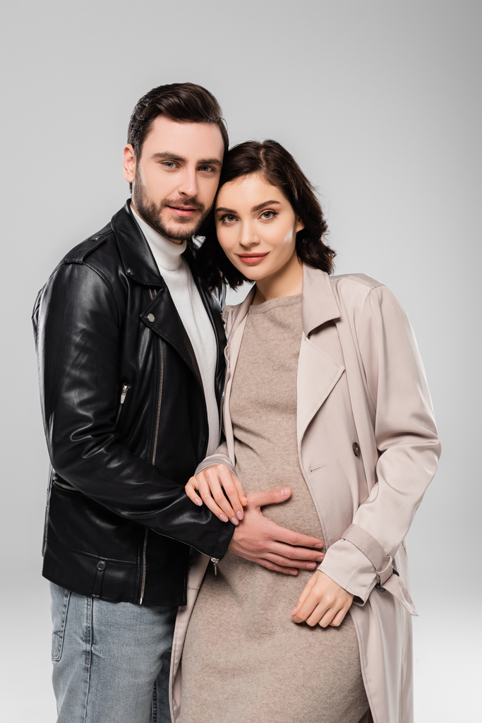Stilvoller Mann steht neben schwangerer Frau isoliert auf grau  - Foto, Bild