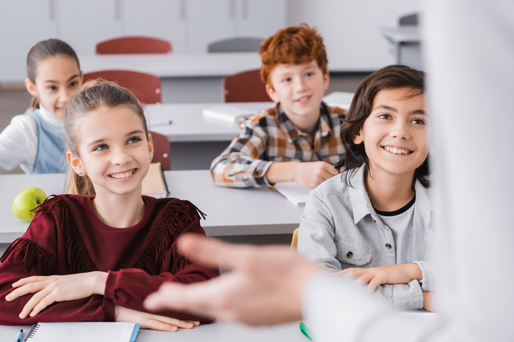 gelukkig schoolkinderen luisteren leraar in klas op wazig voorgrond - Foto, afbeelding