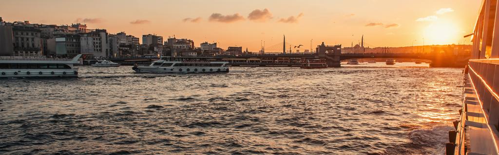 Barcos flotando en el agua de mar cerca de la ciudad de Estambul durante la puesta del sol, Turquía, bandera - Foto, imagen