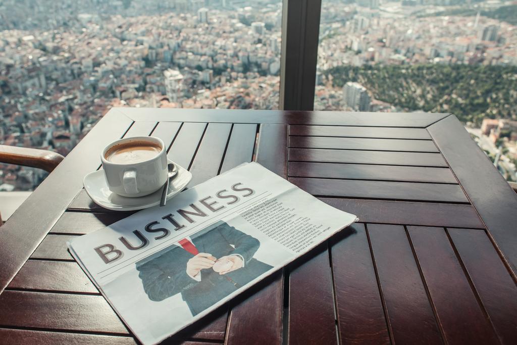 zakelijke krant en koffiekop in cafe in de buurt van venster met luchtfoto van Istanbul - Foto, afbeelding