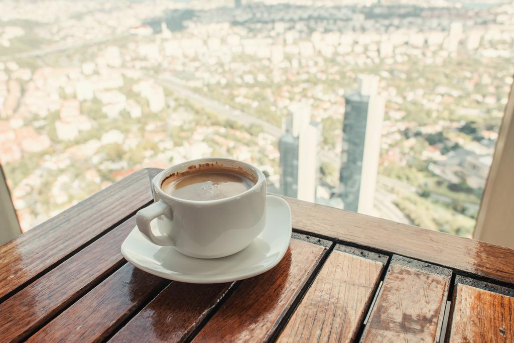 tazza di caffè sul tavolo in legno vicino alla finestra con vista aerea di Istanbul - Foto, immagini