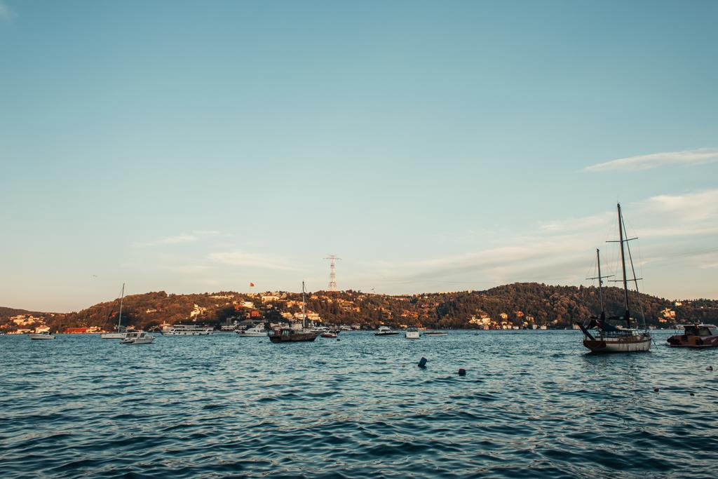 ボスポラス海峡のヨット、緑の丘、イスタンブール、トルコの街の景色 - 写真・画像