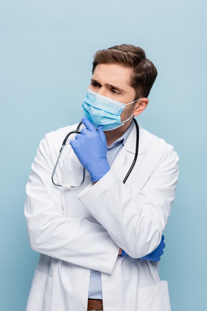 医者のマスクと白いコートに青い線で隔離された聴診器 - 写真・画像
