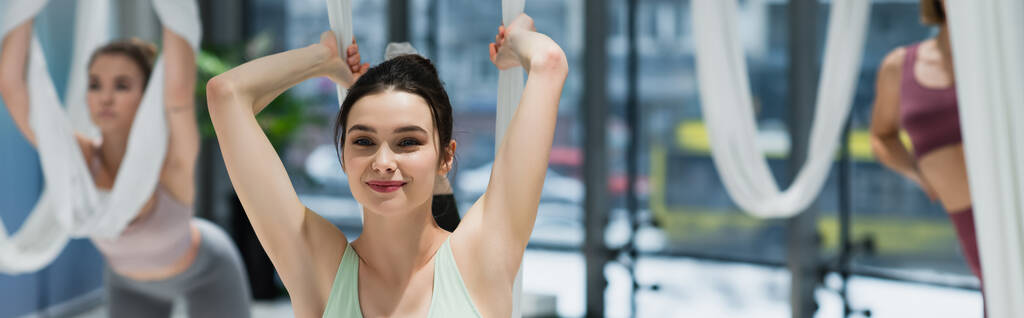 szczęśliwa kobieta ćwiczenia z mucha hamak jogi na rozmytym tle, baner - Zdjęcie, obraz