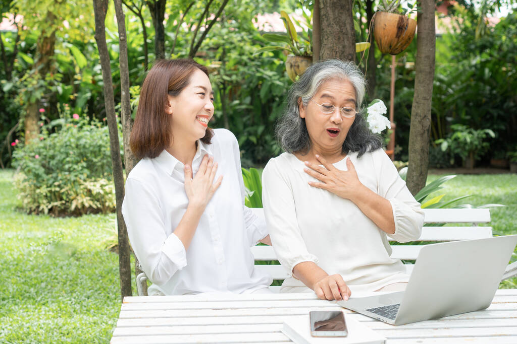 Asiatische Tochter Lehre alte ältere Frau verwenden Online-Social-Media in Computer-Laptop nach der Pensionierung. Konzept der Lerntechnologie und der Anpassung älterer Menschen - Foto, Bild