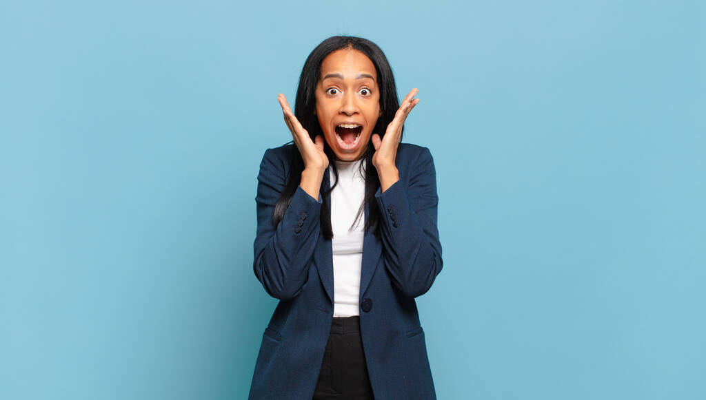 молода чорна жінка відчуває себе шокованою і схвильованою, сміючись, здивованою і щасливою через несподіваний сюрприз. бізнес-концепція
 - Фото, зображення