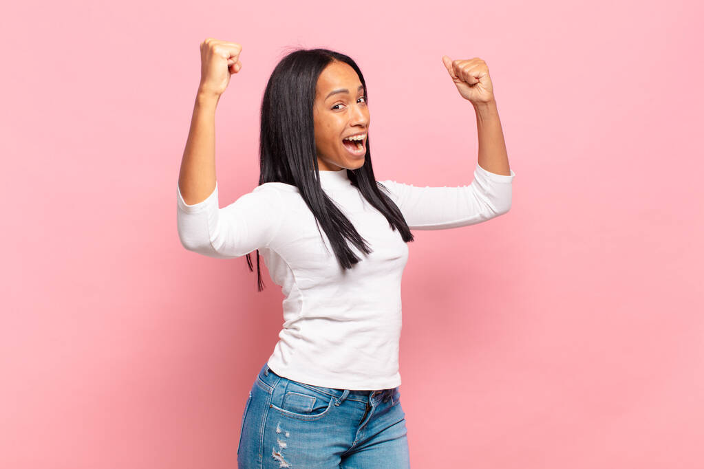 jeune femme noire criant triomphalement, ressemblant à un gagnant excité, heureux et surpris, célébrant - Photo, image