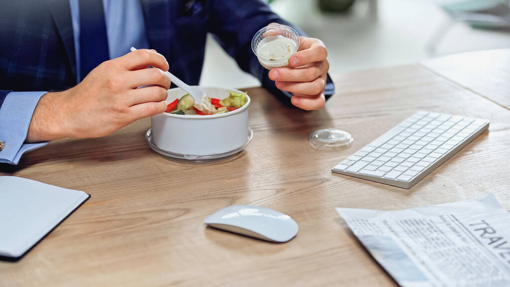cropped view of businessman holding plastic fork near takeaway salad  - Photo, Image