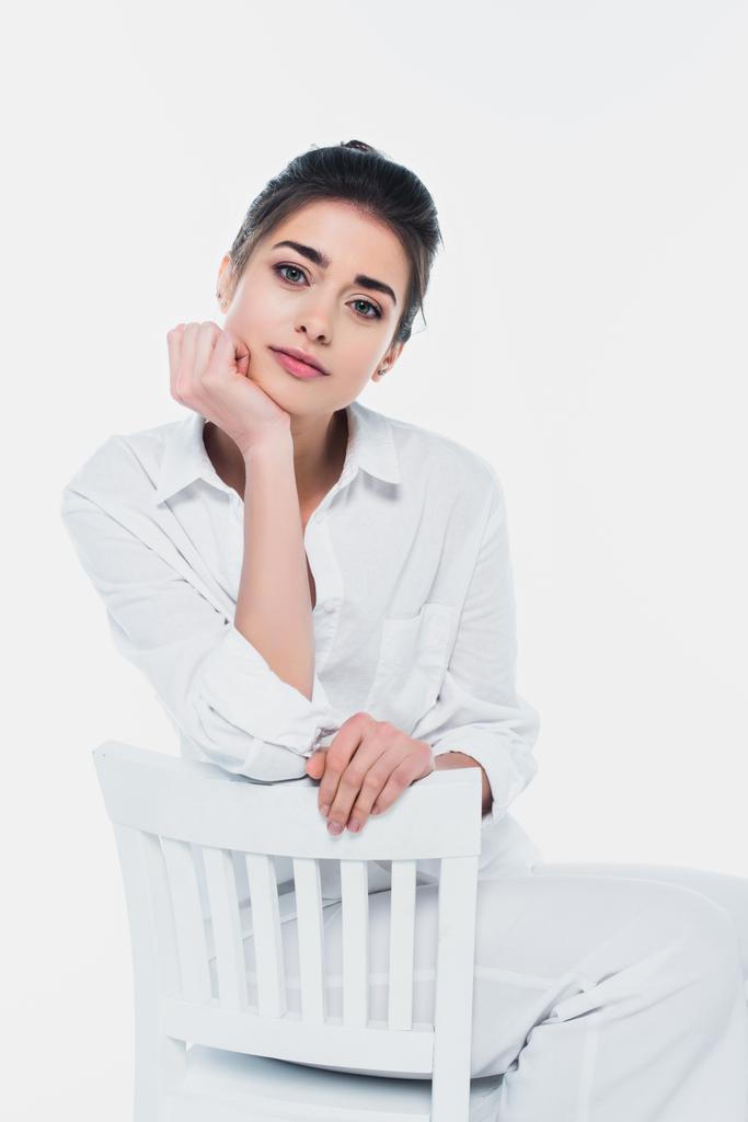 Junge brünette Frau sitzt auf Stuhl isoliert auf weiß - Foto, Bild