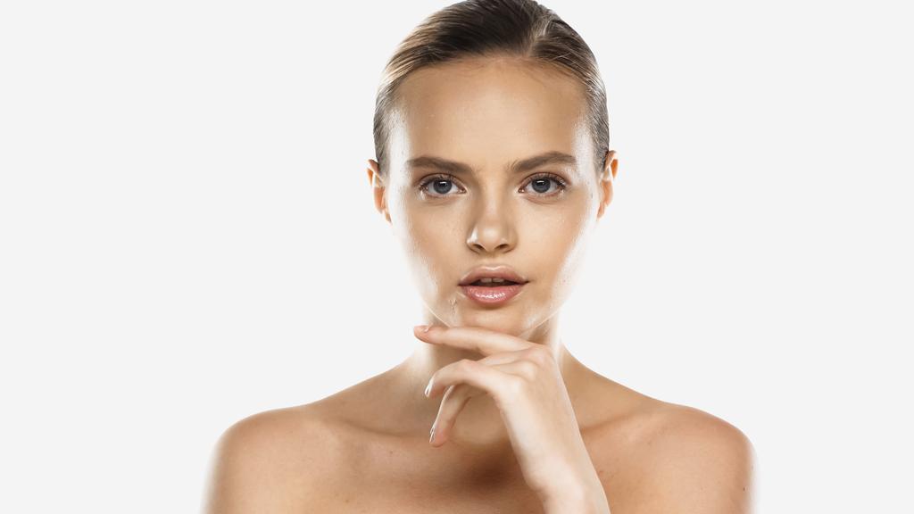 young woman with bare shoulders and clean face looking at camera isolated on white - Photo, Image