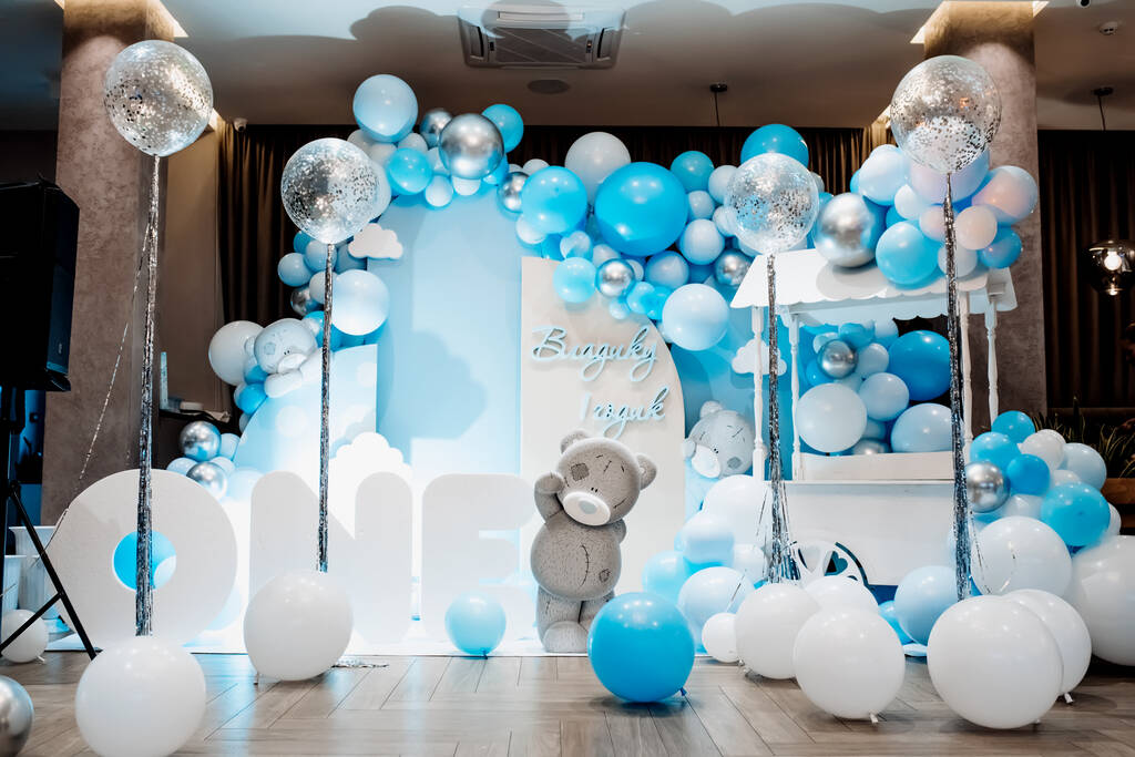 Festive background decoration letters saying one and white blue balloons in studio. Baby birthday theme with teddy bear. Baby Boy. Cake Smash first year concept. birthday greetings. Candy bar. - Zdjęcie, obraz