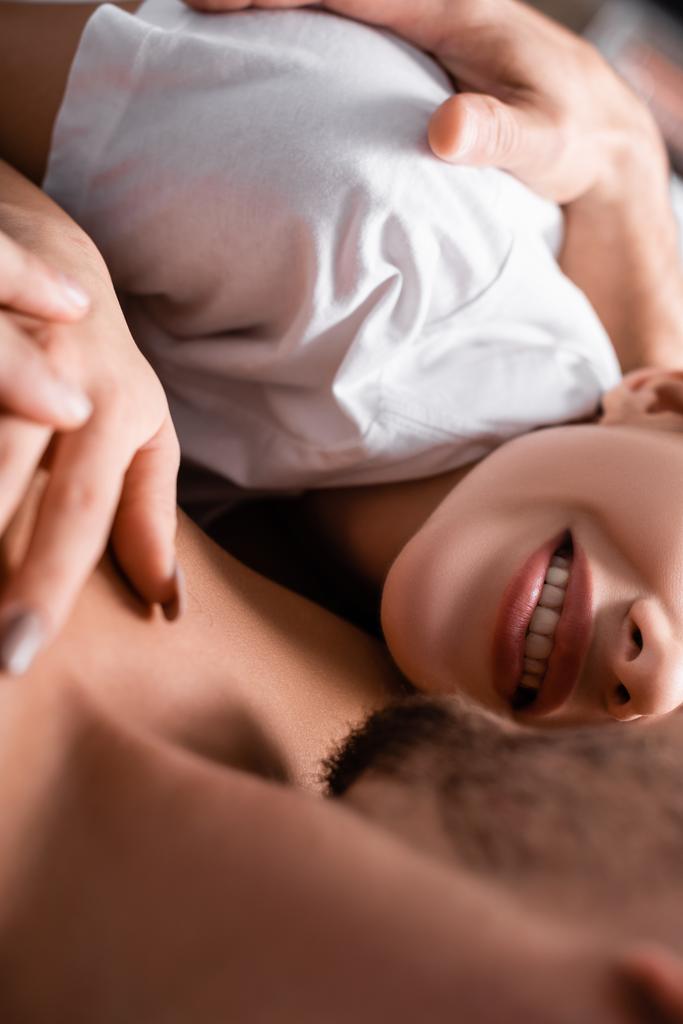 Cropped view of shirtless man hugging smiling girlfriend in t-shirt  - Photo, Image