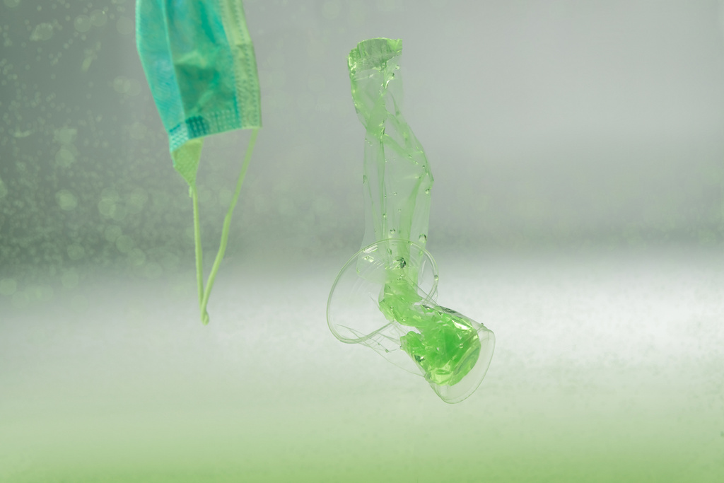 máscara médica, bolsa de plástico y taza bajo el agua, concepto de ecología - Foto, imagen