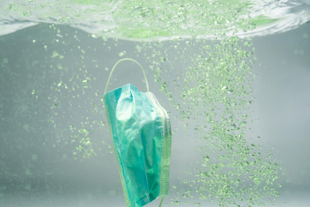 использована медицинская маска в воде, экологическая концепция - Фото, изображение
