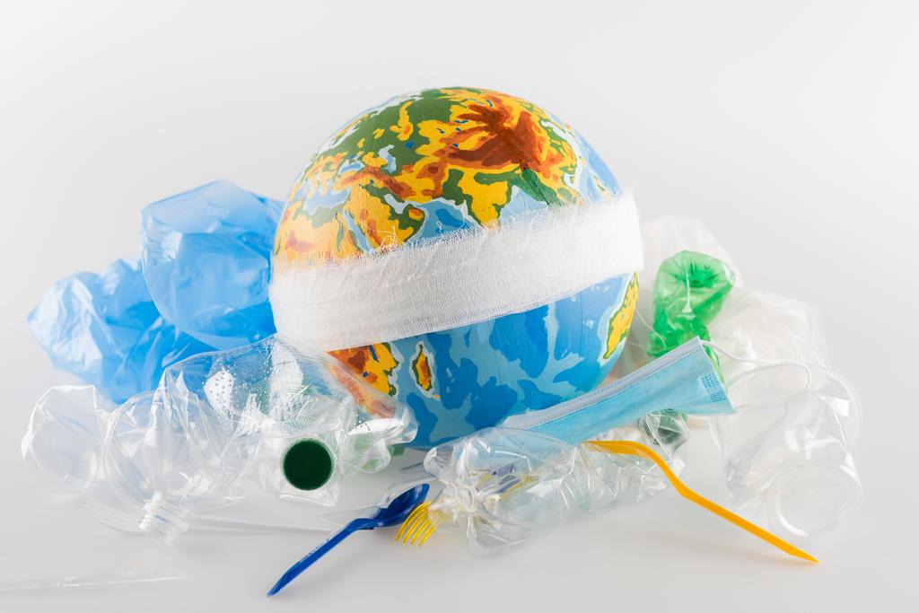 bekötözött földgömb közelében műanyag hulladék szürke, ökológia koncepció - Fotó, kép