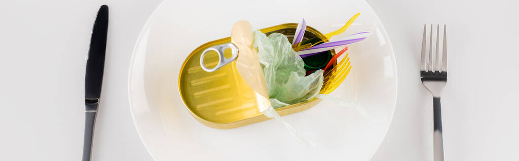 верхний вид вилки и ножа рядом банка с пластиковым мусором на белом, экологическая концепция, баннер - Фото, изображение