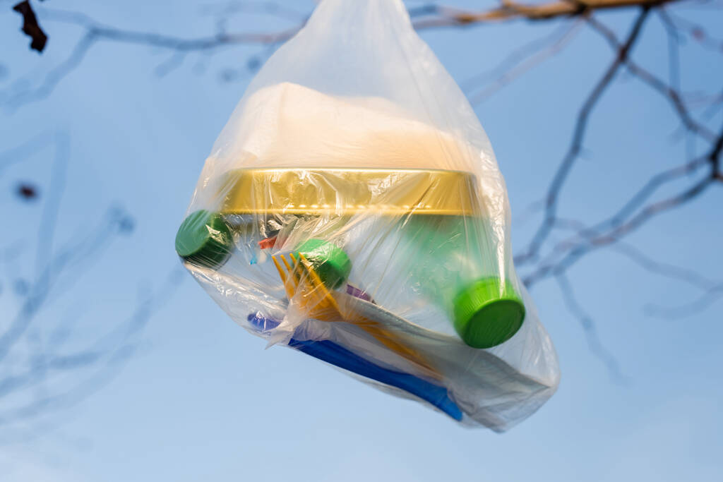 polyethylene bag with can and plastic bottles against blue sky, ecology concept - Photo, Image