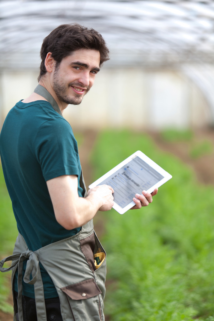 Joven agricultor de negocios trabajando en su tableta
 - Foto, Imagen