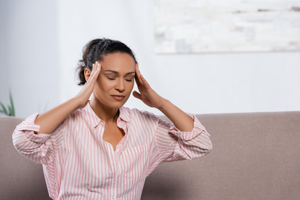 Afrikkalainen amerikkalainen nainen kärsii päänsärky olohuoneessa  - Valokuva, kuva