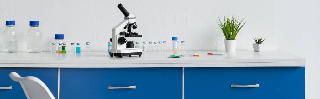 Vakcinák, tabletták és mikroszkóp az asztalon laboratóriumi, banner  - Fotó, kép