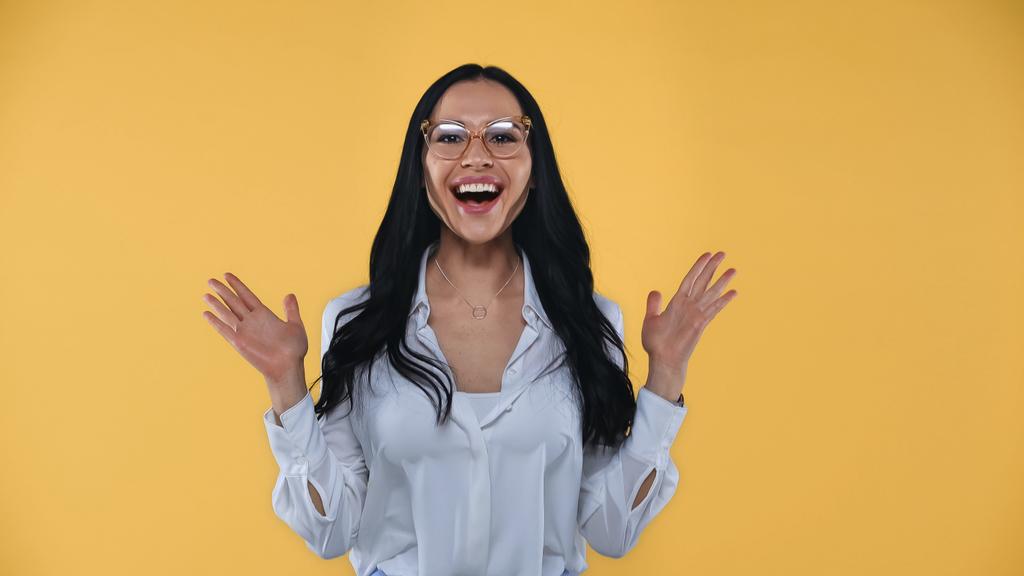 mujer de negocios sorprendida en gafas que muestran wow gesto aislado en amarillo - Foto, Imagen